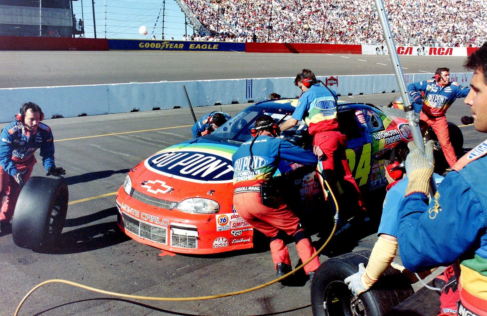 The Rainbow Warriors pit crew servicing Jeff Gordon's No. 24 DuPont Chevrolet in 1997