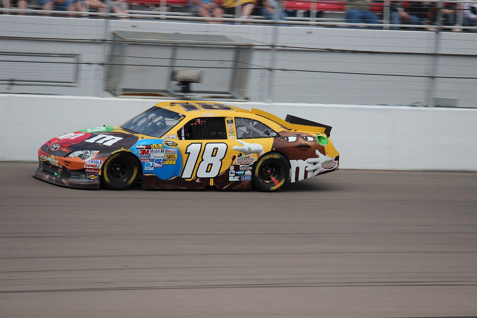 Kyle Busch's yellow No. 18 M&M's Toyota at speed at Las Vegas
