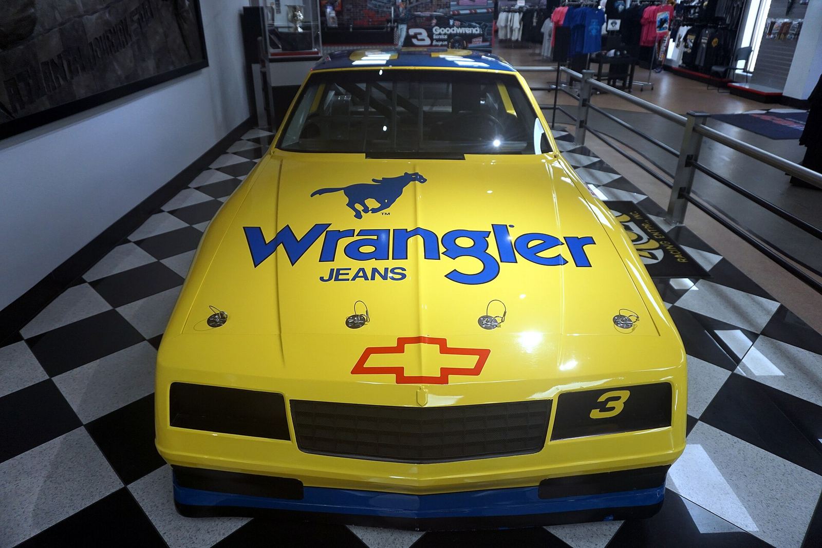 The yellow and blue No. 3 Wrangler Jeans Chevrolet Monte Carlo on display, seen from the front